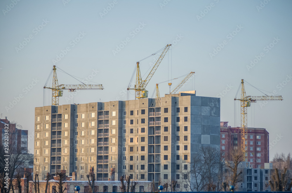 Under construction high-rise building with yellow construction crane Under construction high-rise building with yellow construction crane