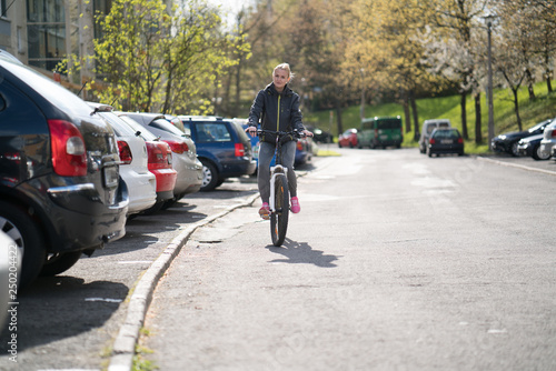 Wallpaper Mural Young woman on a Bicycle, riding around the city near the car Torontodigital.ca