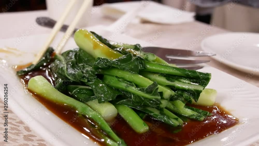 Motion of people eating vegetable on table inside Chinese restaurant with 4k resolution. Motion of people eating vegetable on table inside Chinese restaurant with 4k resolution.