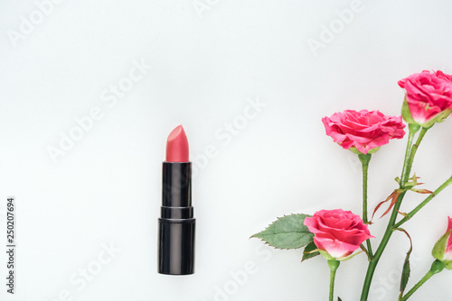 top view of lipstick and pink roses isolated on white
