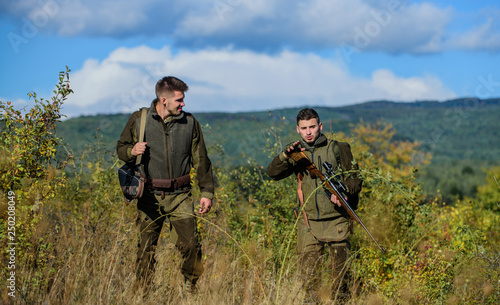 Military uniform fashion. Friendship of men hunters. Hunting skills and weapon equipment. How turn hunting into hobby. Army forces. Camouflage. Man hunters with rifle gun. Masculine hobby activity