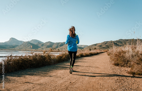 Young fitness woman running in the nature