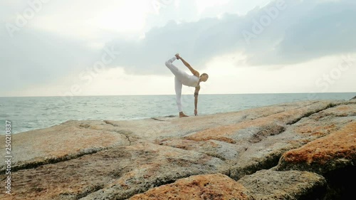 Woman training yoga pose King Dance of Nataraja and warrior pose Virabhadrasana photo