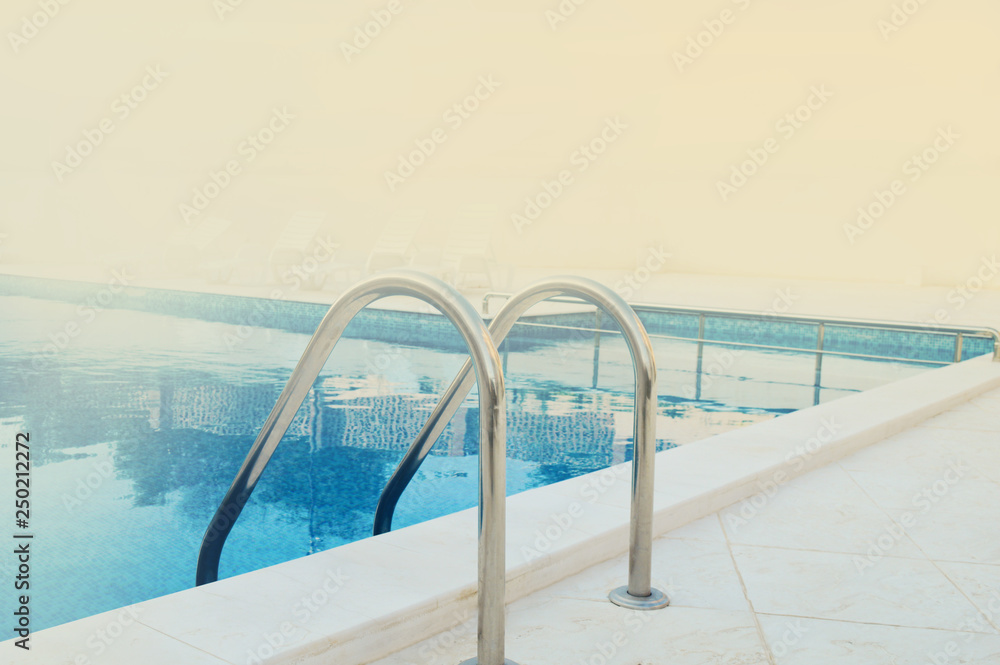 metal railings and swimming pool in the foggy summer morning, with space for text metal railings and swimming pool in the foggy summer morning, with space for text