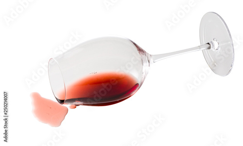 Foto Spilled red wine out of glass on white background