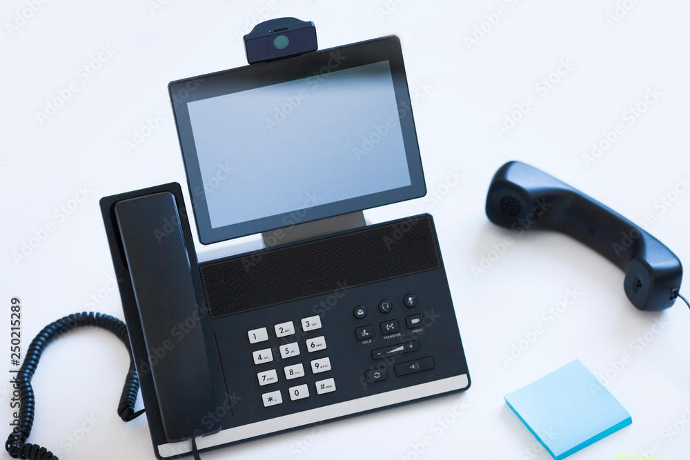 Ip telephony concept. Modern ip phones, sip terminals, conference phones and cameras for video meetings on office background. Top view. Ip telephony concept. Modern ip phones, sip terminals, conference phones and cameras for video meetings on office background. Top view.