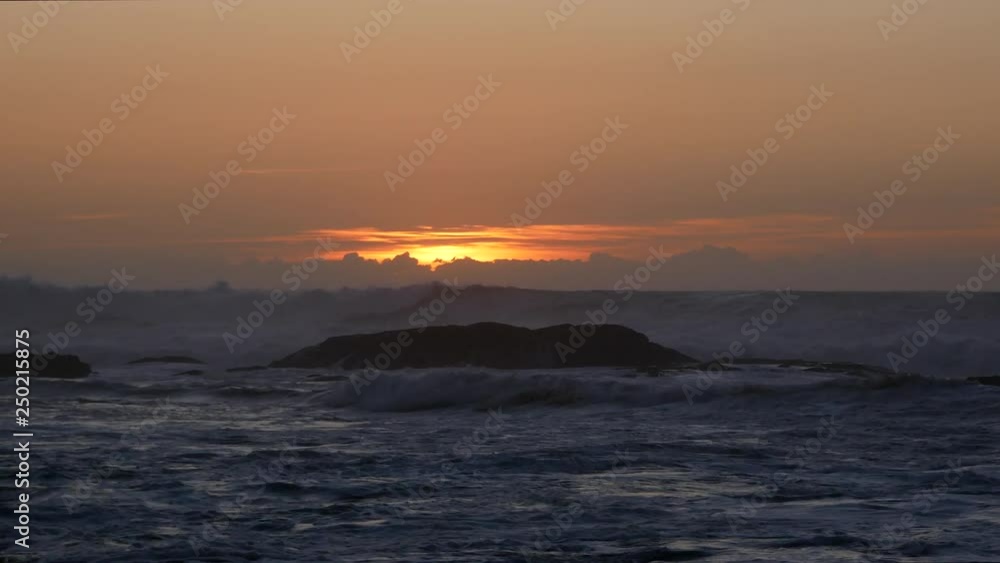 Rough sea with choppy white wave at dusk / early evening, with orange sky Rough sea with choppy white wave at dusk / early evening, with orange sky