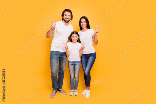 Full length body size view portrait of nice sweet lovely attractive adorable charming cheerful people mom dad pre-teen girl showing v-sign isolated over shine vivid pastel yellow background © deagreez