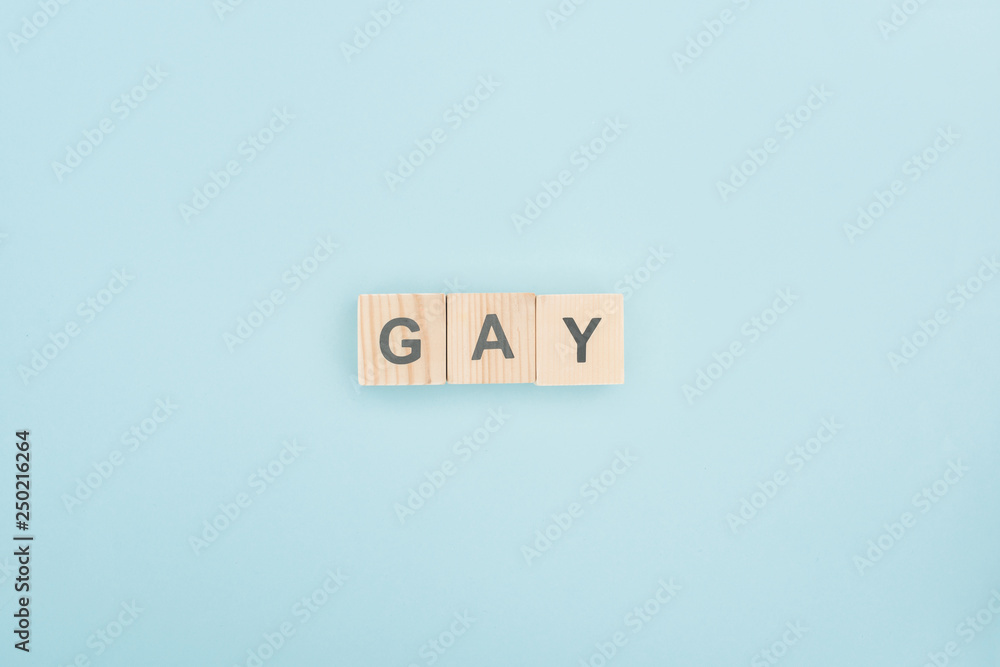 top view of gay lettering made of wooden cubes on blue background top view of gay lettering made of wooden cubes on blue background