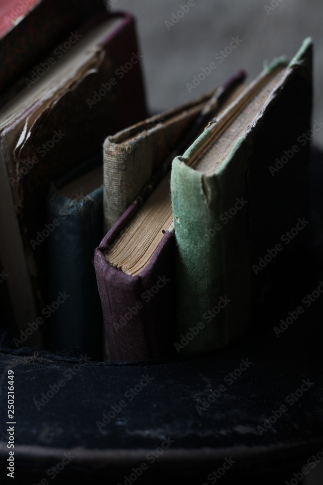 Old books and a cylinder on wooden background