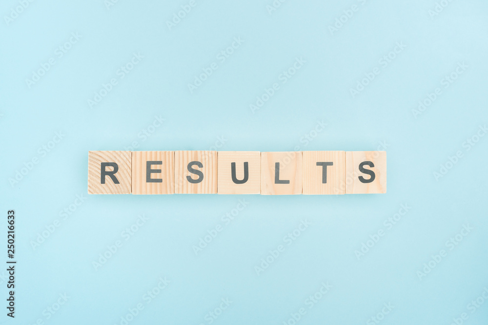top view of results lettering made of wooden cubes on blue background top view of results lettering made of wooden cubes on blue background