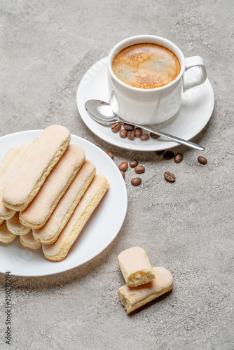 Italian Savoiardi ladyfingers Biscuits and cup of coffee on concrete backgound