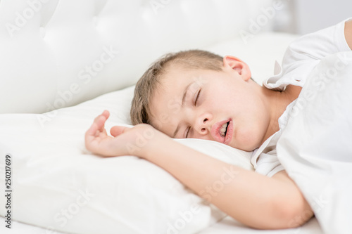Young boy is sleeping with his mouth open, snoring