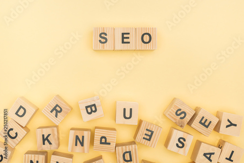 top view of seo lettering with wooden cubes on yellow background