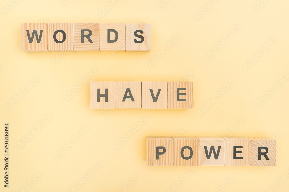top view of phrase words have power lettering with wooden cubes on yellow background