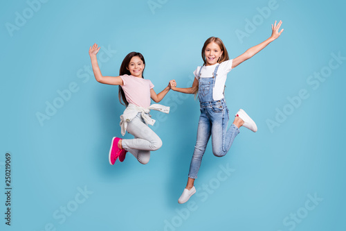 Full length body size view of two people nice-looking crazy cute lovely attractive cheerful careless straight-haired pre-teen girls having fun great day overjoy isolated over blue pastel background © deagreez