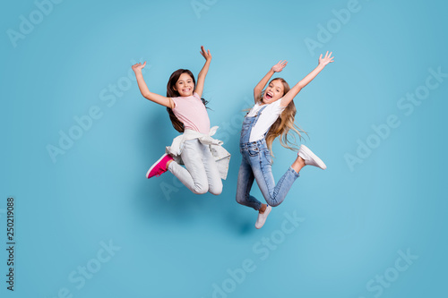 Full length body size view of two people nice-looking crazy lovely attractive cheerful carefree straight-haired pre-teen girls having fun great weekend time overjoy isolated over blue pastel