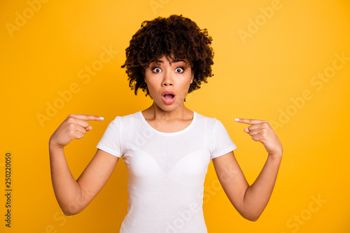Close up photo sweet beautiful amazing she her dark skin lady arms hands fingers pointing self it is not my fault guilty wearing casual white t-shirt isolated yellow bright vivid background