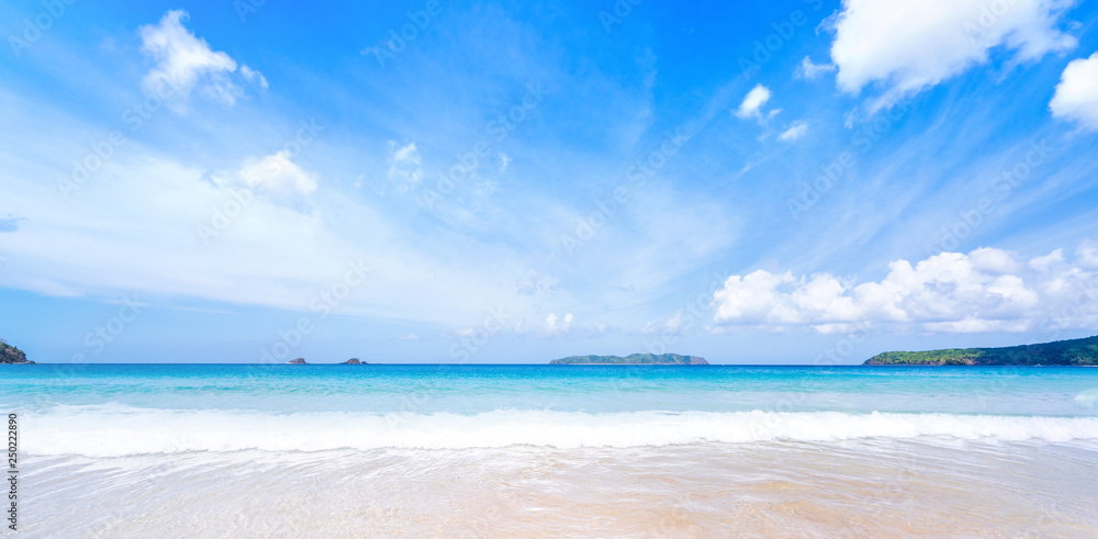 Beautiful amazing gold colored sandy beach with soft waves isolated with sunny blue sky. Concept of tropical calm tourism idea, copy space, close up