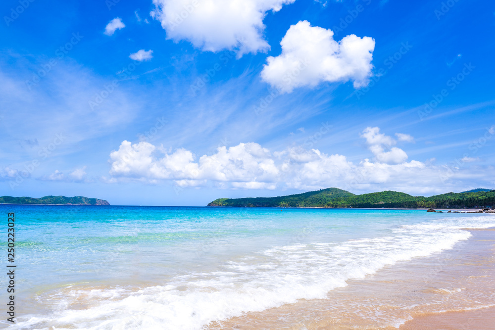 Beautiful amazing gold colored sandy beach with soft waves isolated with sunny blue sky. Concept of tropical calm tourism idea, copy space, close up Beautiful amazing gold colored sandy beach with soft waves isolated with sunny blue sky. Concept of tropical calm tourism idea, copy space, close up