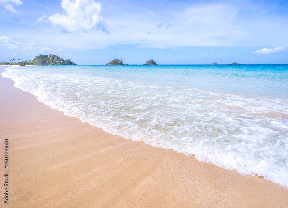 Beautiful amazing gold colored sandy beach with soft waves isolated with sunny blue sky. Concept of tropical calm tourism idea, copy space, close up Beautiful amazing gold colored sandy beach with soft waves isolated with sunny blue sky. Concept of tropical calm tourism idea, copy space, close up