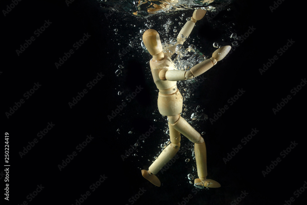 Concept of dived with wooden human mannequin. Wooden man dived in water. Wooden man. Wooden mannequin.