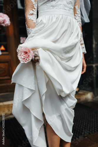 Wedding details. Bride holds tender pink bouquet in her arms. No face