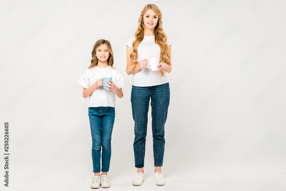 pretty woman with adorable daughter holding coffee cups on white background pretty woman with adorable daughter holding coffee cups on white background