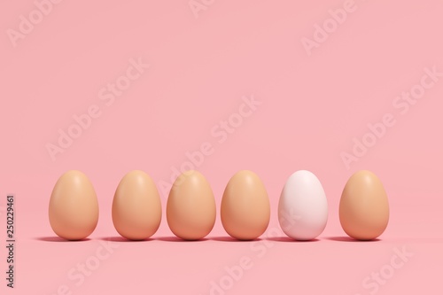 Outstanding white Egg among brown eggs on pink background. minimal Easter idea.