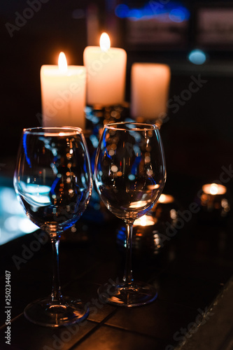 empty wine glasses and candles with illumination lights background. Romantic dinner dating night in bar or restaurant . 