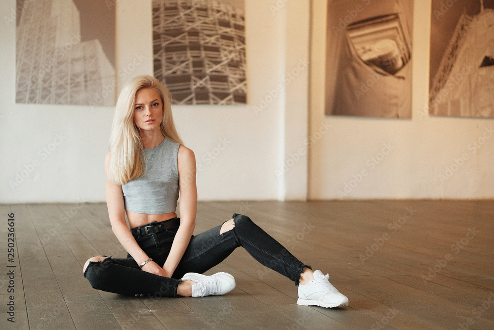 Blond girl posing for photo at the gallery