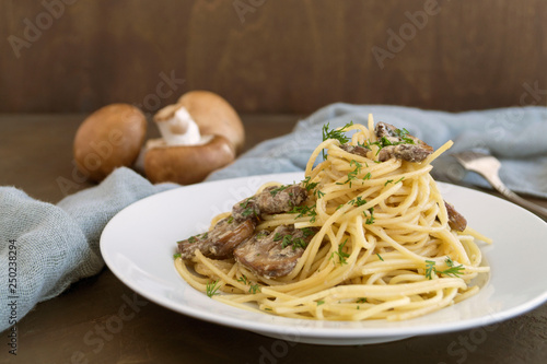 Spaghetti with mushrooms in cream sauce. on dark background