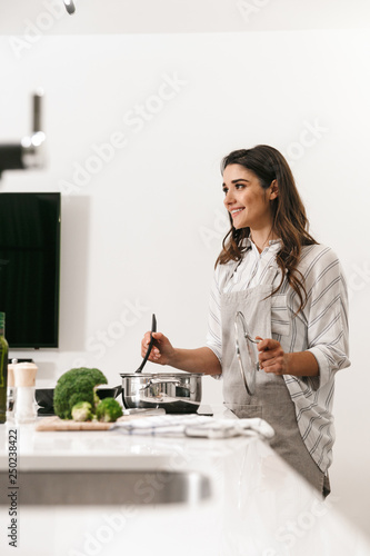 Beautiful young woman cooking healthy dinner