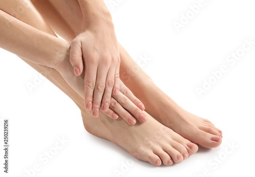 Fototapeta Naklejka Na Ścianę i Meble -  Legs and hands of young woman with beautiful pedicure and manicure on white background