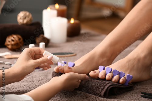 Young woman getting pedicure in beauty salon