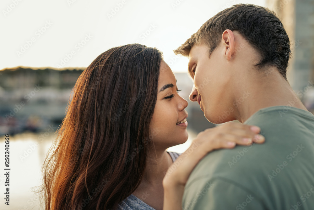 Romantic young couple standing by a harbor about to kiss Romantic young couple standing by a harbor about to kiss