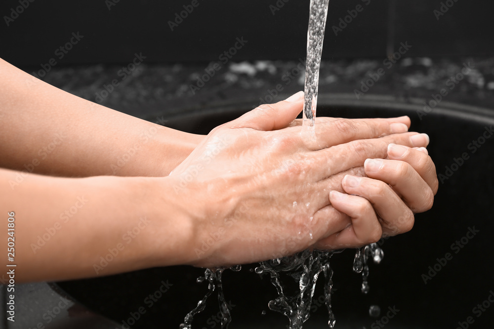 Woman washing hands in sink