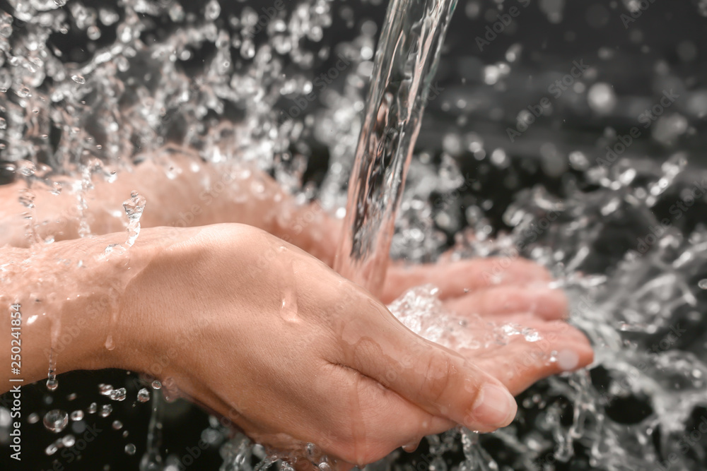 Fototapeta premium Woman washing hands on dark background