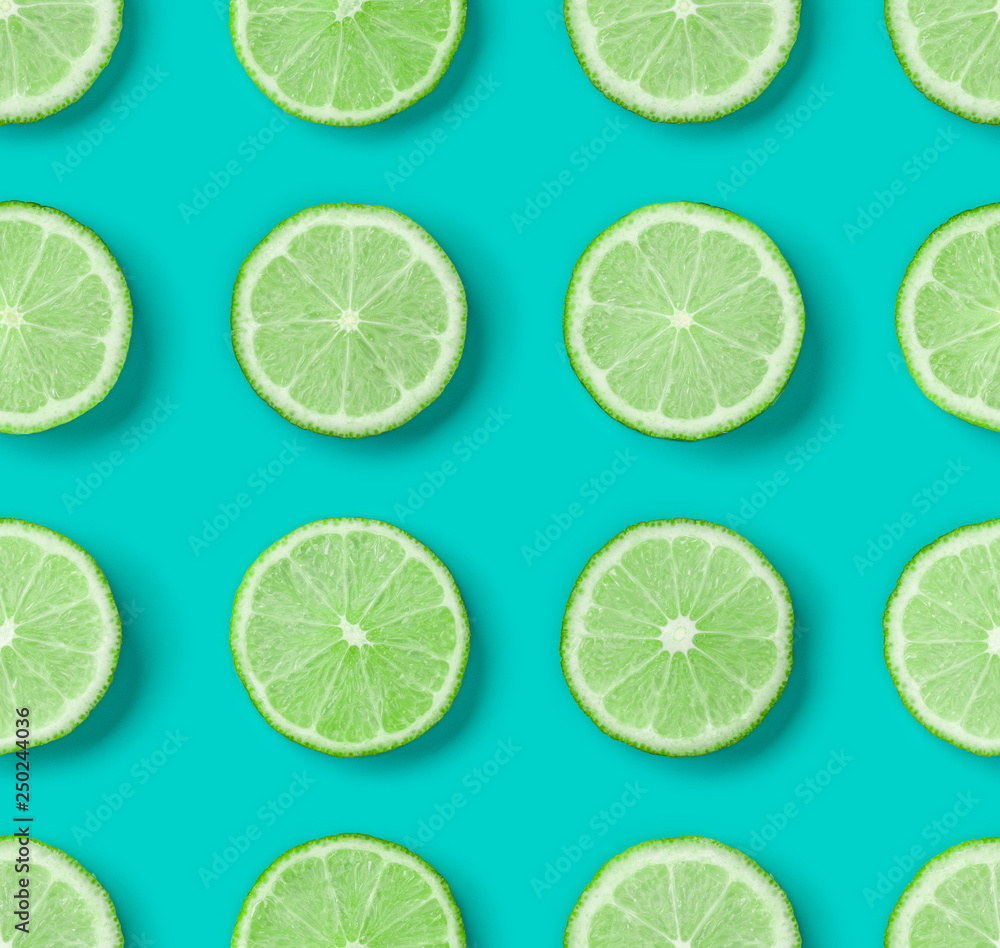 Fruit pattern of lime slices on blue background. Flat lay, top view. .  Pop art design, creative summer concept.. Creative layout.