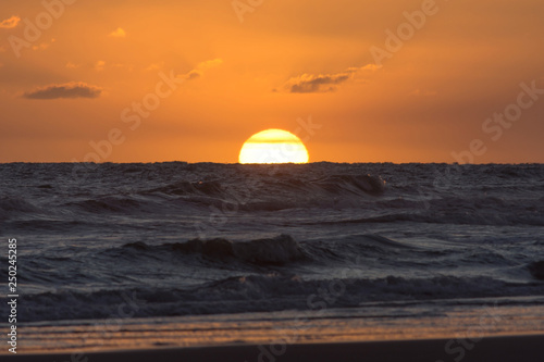 View of the sun hiding in the sea