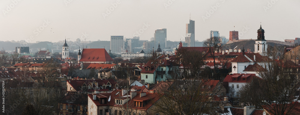 Wide panorama of capital of the republic of Lithuania Vilnius. Late cold winter evening, sun painted sky in red above medieval Vilnius old town. 