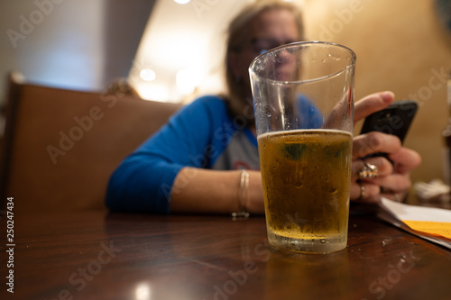 woman is waiting and the beer if half full
