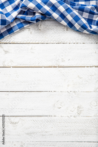Blue checkered kitchen tablecloth on wooden table.