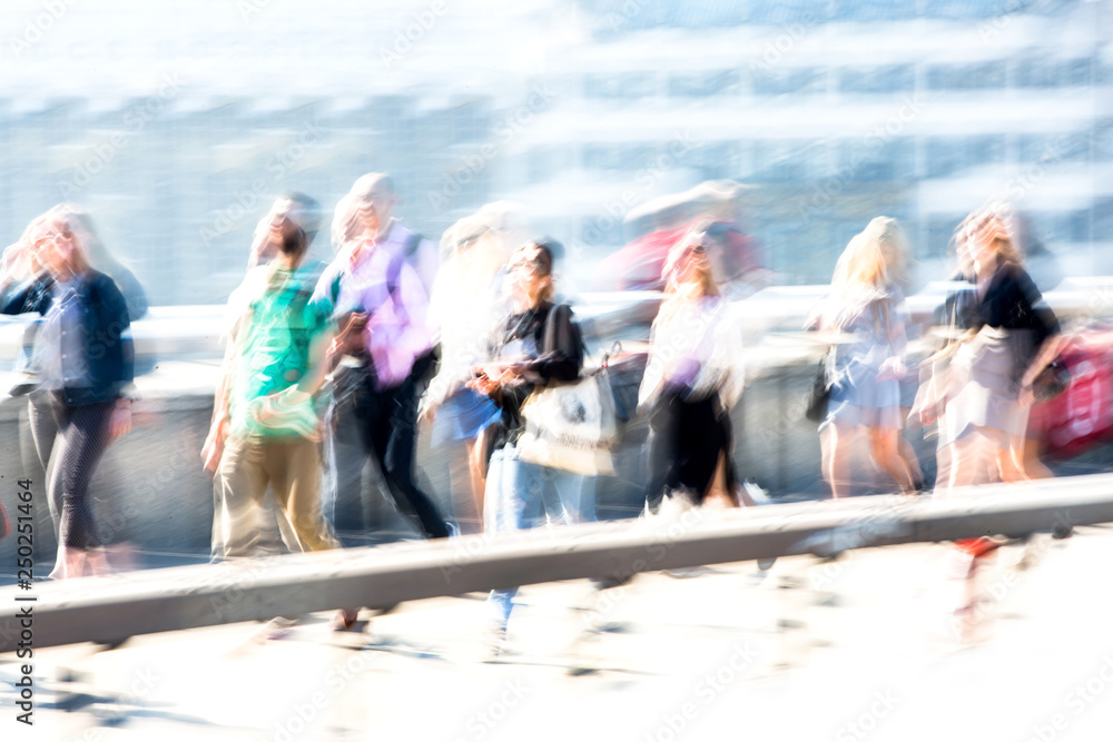 Blur of people walking over the London bridge on the way to work in the City of London. Early morning commuters. 