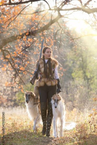 Portrait of a beautiful girl hunter with dogs