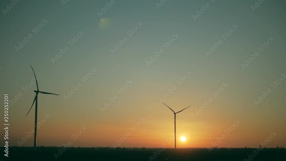 huge wind turbines in the field at sunset, alternative energy huge wind turbines in the field at sunset, alternative energy