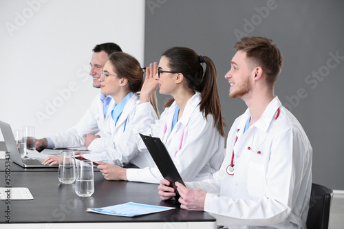 Young doctors sitting at ta...