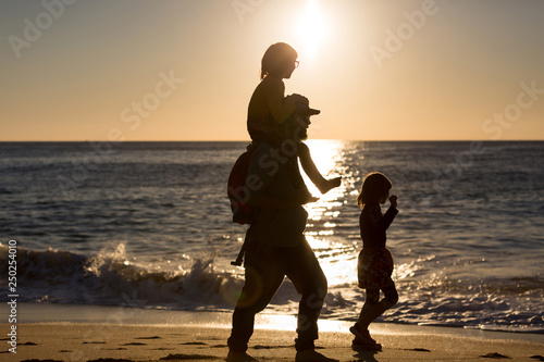Father and children on the beach during sunset, Playa Zahora, Andalucía, Spain photo