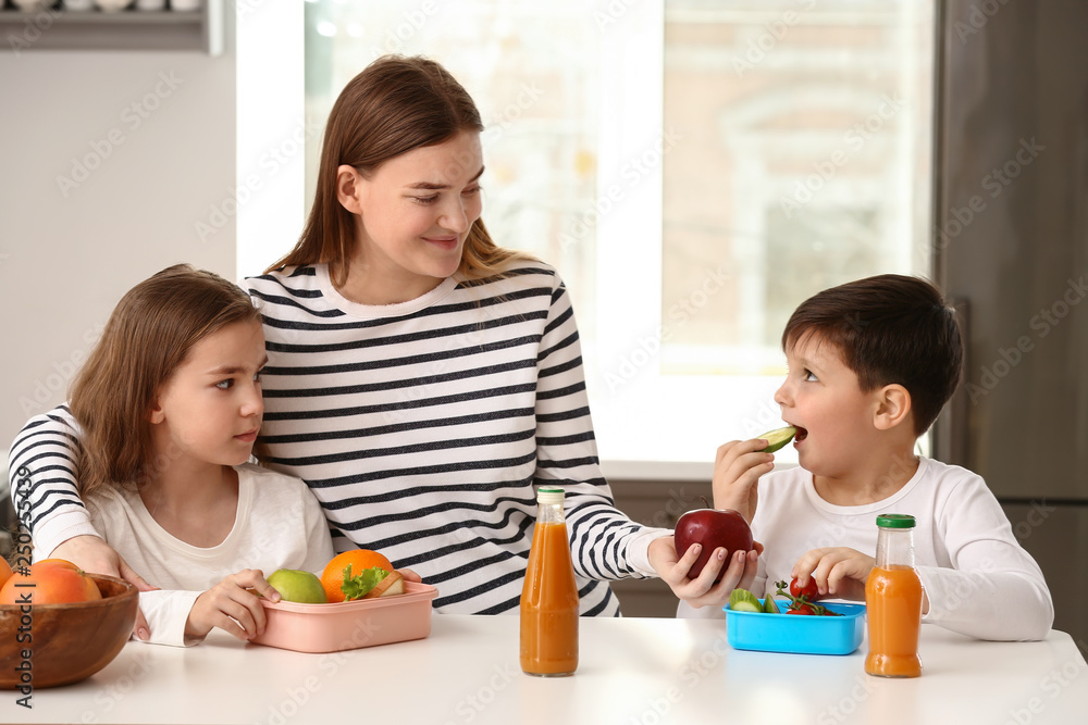 Mother feeding her little children at home Mother feeding her little children at home