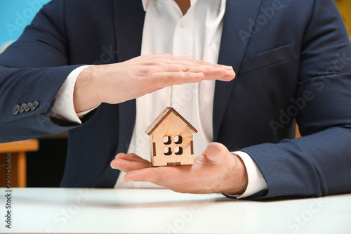 Insurance agent holding figure of house, closeup